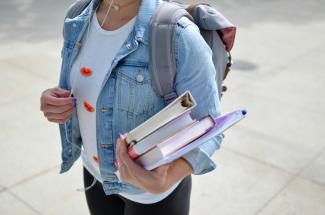 woman wearing blue denim jacket holding book by Element5 Digital courtesy of Unsplash.